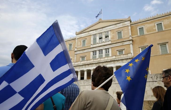 © Reuters. Manifestante segura bandeiras de Grécia e UE durante protesto em Atenas
