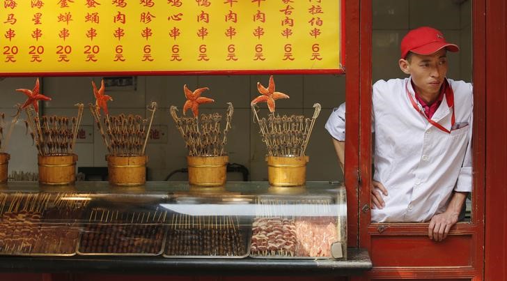 © Reuters. A food vendor waits for customers at a shopping district in Beijing