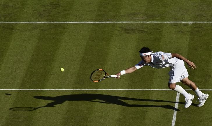 © Reuters. Kei Nishikori of Japan stretches for a shot during his match against Simone Bolelli of Italy at the Wimbledon Tennis Championships in London