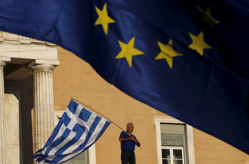 © Reuters. File photo of a protester waving a Greek flag at the entrance of the parliament building during a rally in Athens
