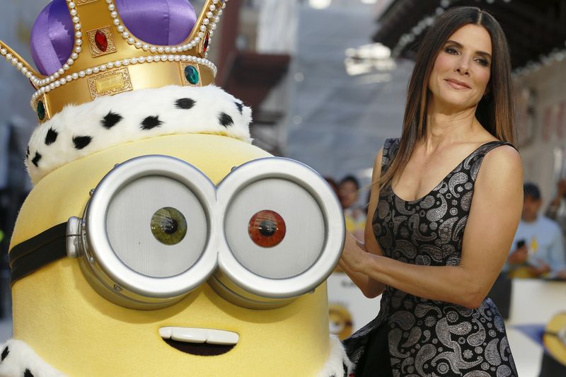 © Reuters. Actress Sandra Bullock poses with a character in costume from the film during the "Minions" World Premiere at Leicester Square in London, Britain 