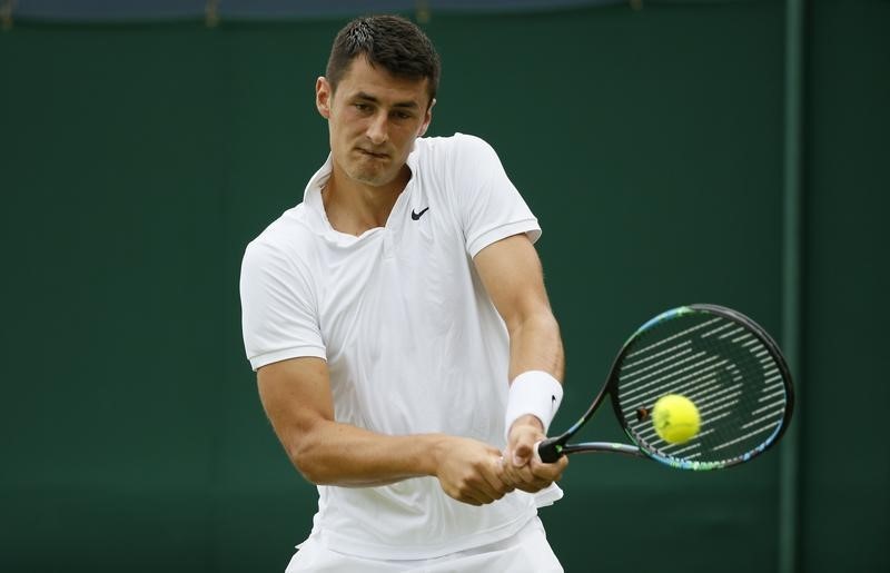 © Reuters. Bernard Tomic of Australia hits a shot during his match against Pierre-Hugues Herbert of France at the Wimbledon Tennis Championships in London