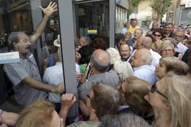 © Reuters. Aposentados se acotovelam para entrar em agência bancária na Grécia
