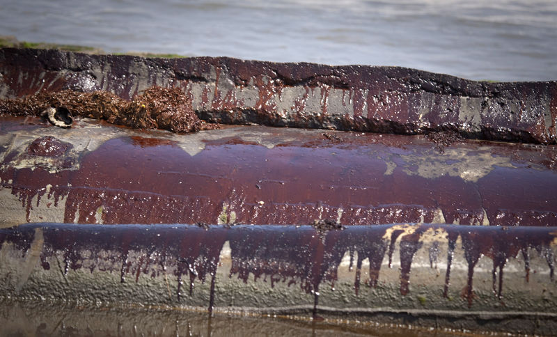 © Reuters. Oil from the Deepwater Horizon Oil Spill coats concrete sea barriers in Port Fourchon