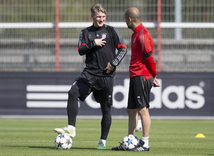 © Reuters. Técnico do Bayern de Munique, Pep Guardiola (direita), conversa com o meia Bastian Schweinsteiger durante treino do time no centro de treinamento do clube, em Munique