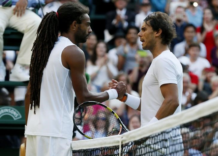 © Reuters. Dustin Brown cumprimenta Rafael Nadal após vitória em Wimbledon 