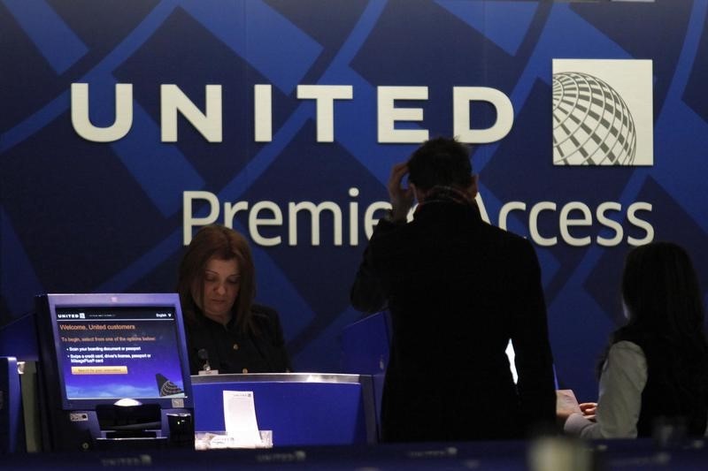 © Reuters. A worker from United attends to some customers during their check in process at Newark International airport in New Jersey