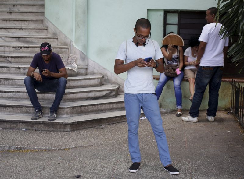 © Reuters. Cubans use the internet via public Wi-Fi in Havana