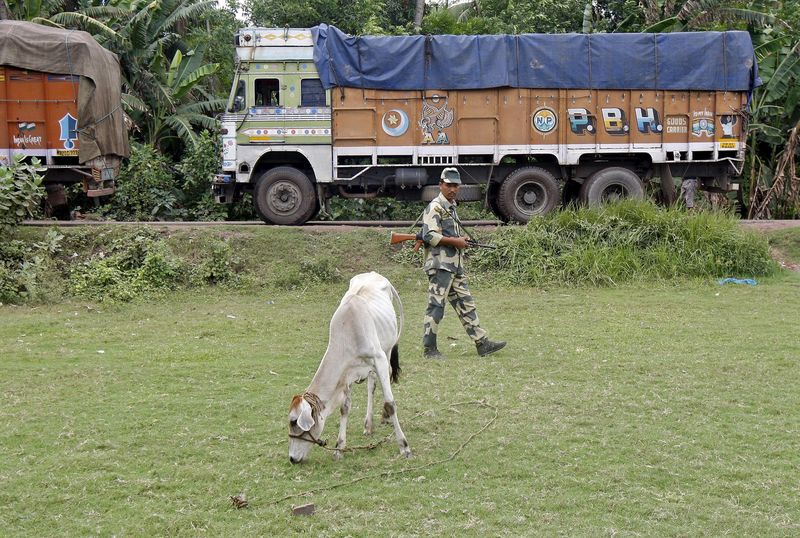 © Reuters. Indian BSF soldier patrols as trucks wait to cross the India-Bangladesh check-post in West Bengal