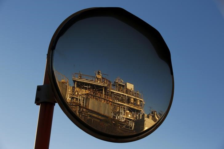 © Reuters. A petro-industrial factory is reflected in a traffic mirror in Kawasaki near Tokyo