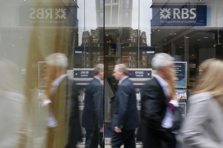 © Reuters. Pedestrians are reflected in the glass of an advertising board as they walk past a branch of The Royal Bank of Scotland in central London