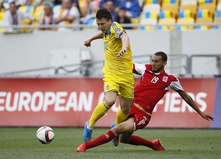 © Reuters. Ukraine's Konoplyanka and Luxembourg's Holter fight for the ball during their Euro 2016 Group C qualifying soccer match at the Arena Lviv stadium in Lviv