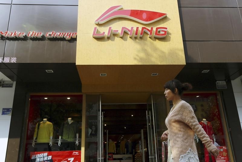 © Reuters. A woman walks past a Li Ning sportswear store in Huaibei