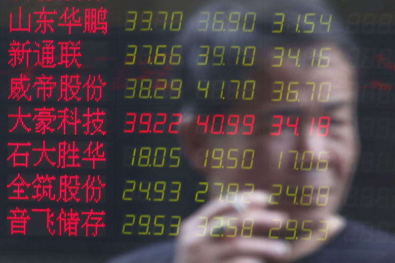 © Reuters. An investor is reflected on an electronic board showing stock information at a brokerage house in Shanghai