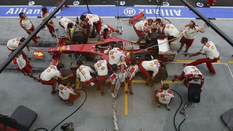 © Reuters. Crew members of the Ferrari Formula One team practise pit stops prior to the start of the third practice session of the Singapore F1 Grand Prix at the Marina Bay street circuit