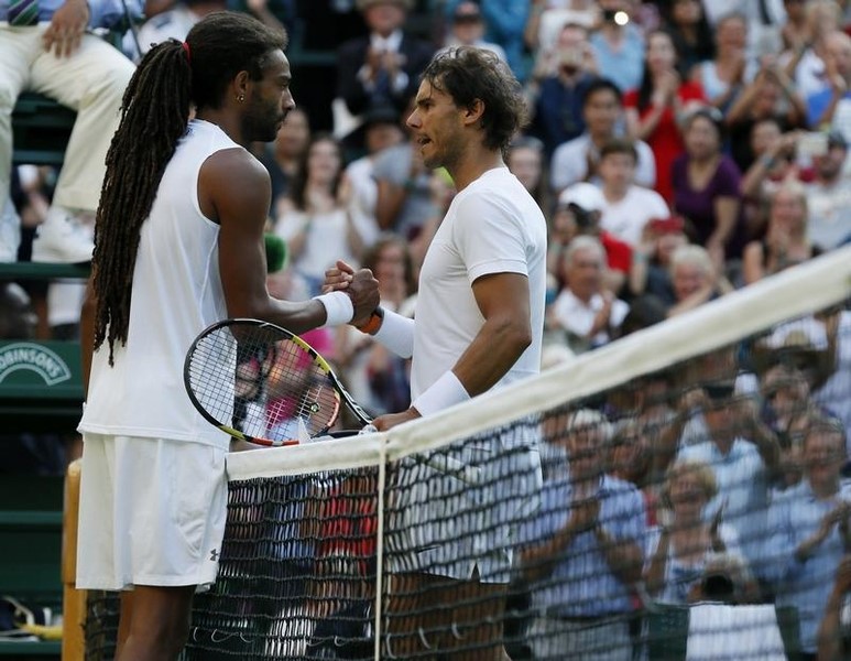 © Reuters. Dustin Brown of Germany shakes hands with Rafael Nadal of Spain after winning their match at the Wimbledon Tennis Championships in London