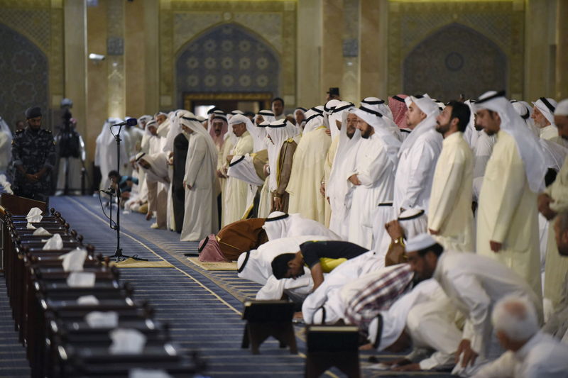© Reuters. Sunni and Shi'ite worshippers, together with Emir Sheikh Sabah al Ahmed al Sabah, pray at the Grand Mosque of Kuwait, in Kuwait City