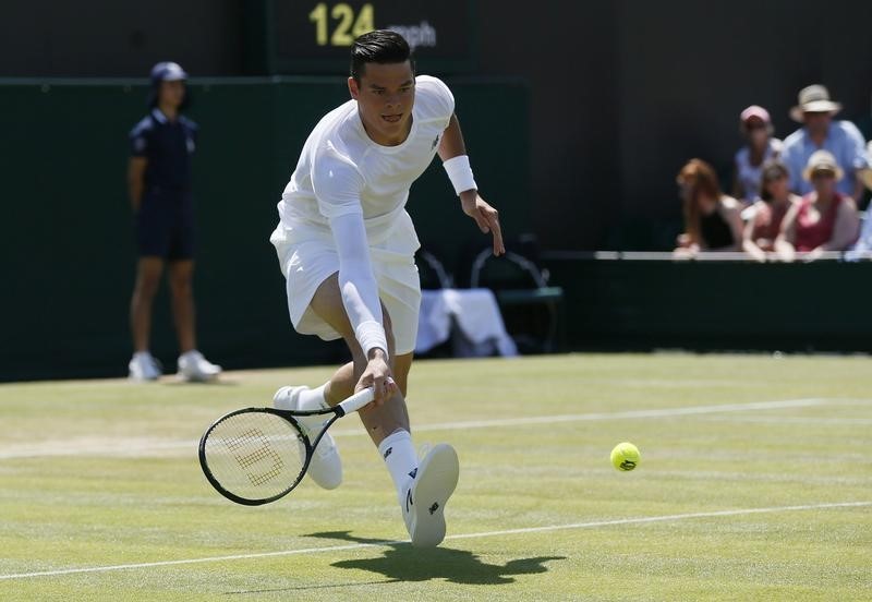 © Reuters. Milos Raonic of Canada hits a shot during his match against Nick Kyrgios of Australia at the Wimbledon Tennis Championships in London