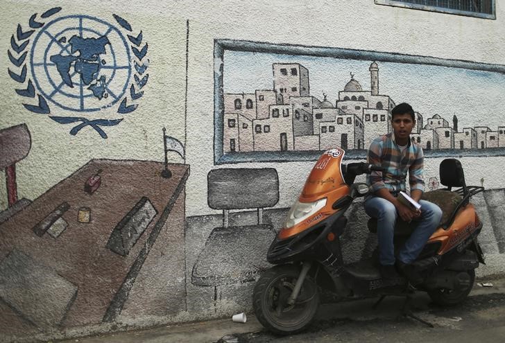 © Reuters. Palestino ao lado da entrada de prédio da ONU em Gaza