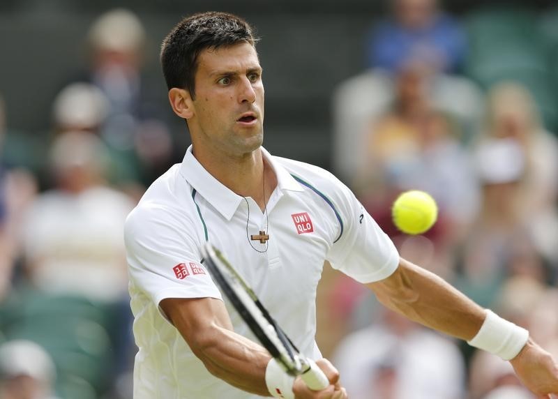 © Reuters. Novak Djokovic of Serbia hits a shot during his match against Bernard Tomic of Australia at the Wimbledon Tennis Championships in London