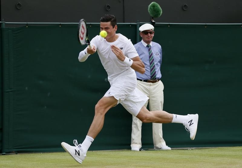 © Reuters. Milos Raonic of Canada hits a shot during his match against Nick Kyrgios of Australia at the Wimbledon Tennis Championships in London