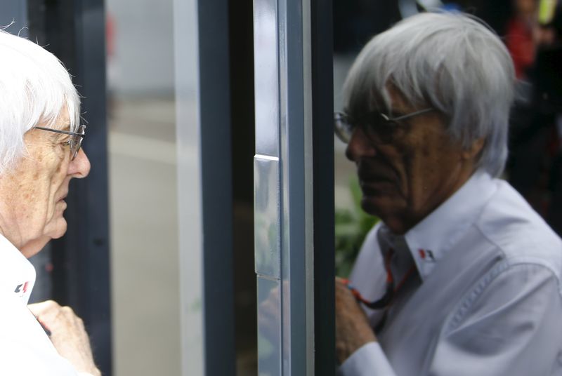 © Reuters. Formula One impresario Ecclestone is reflected in the window of his bus before the start of the Austrian F1 Grand Prix at the Red Bull Ring circuit in Spielberg