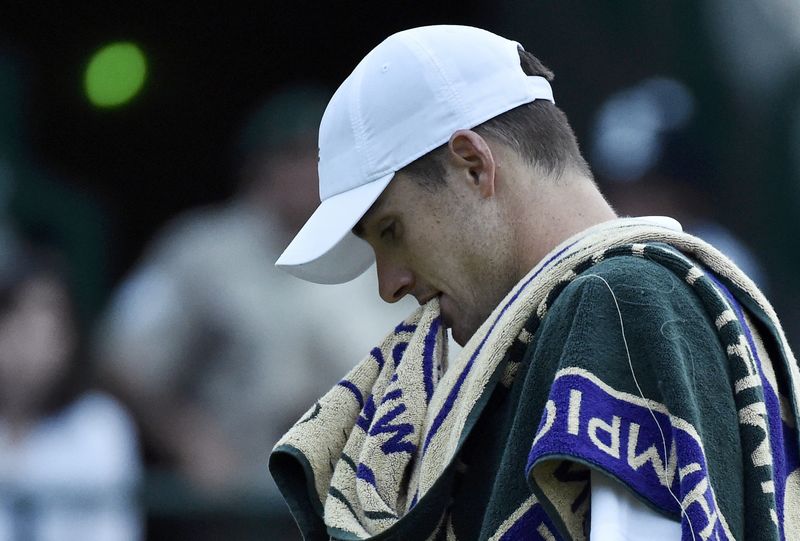 © Reuters. John Isner of the U.S.A. bites his towel during his match against Marin Cilic of Croatia at the Wimbledon Tennis Championships in London