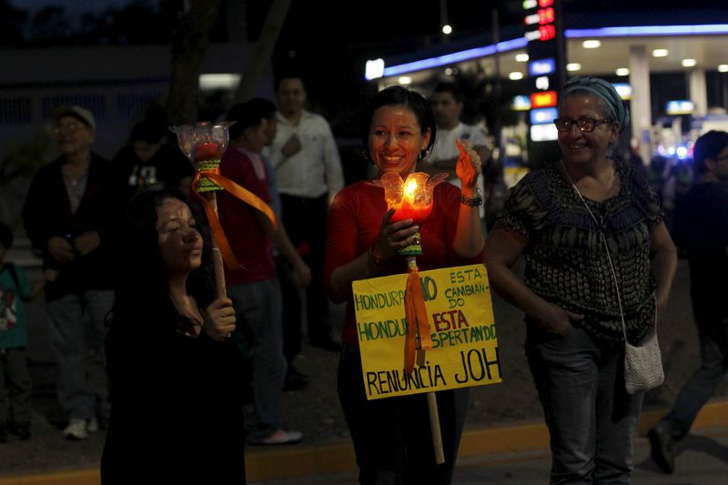 © Reuters. Miles de personas marchan en Honduras pidiendo la dimisión del presidente Hernández