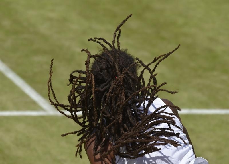 © Reuters. Dustin Brown of Germany serves during his match against Viktor Troicki of Serbia at the Wimbledon Tennis Championships in London