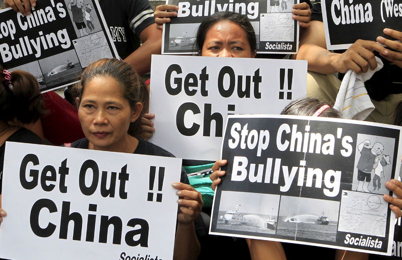 © Reuters. Protesters from the Socialista National Confederation of Labor activist group display placards during a rally over the South China Sea disputes with China, outside the Chinese Consulate in Makati City