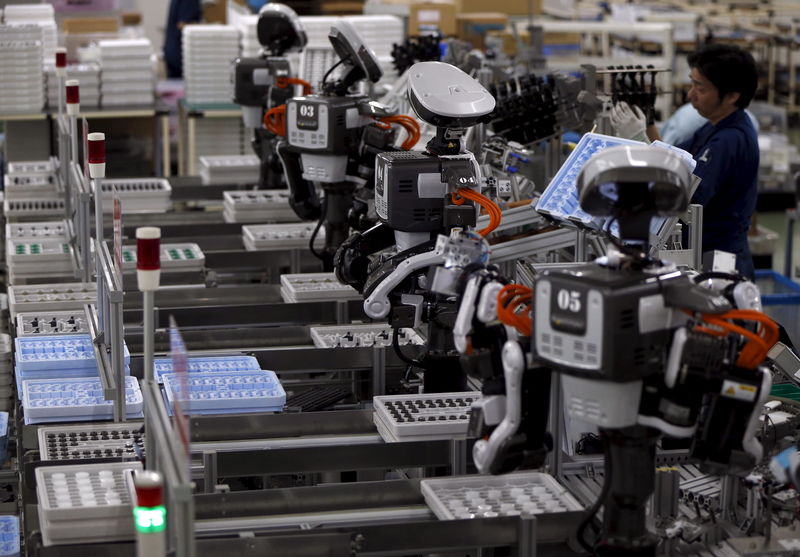 © Reuters. File photo of humanoid robots working side by side with employees in the assembly line at a factory of Glory Ltd., a manufacturer of automatic change dispensers, in Kazo, north of Tokyo