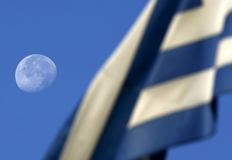 © Reuters. The moon sets behind a Greek flag over a polling station in Athens