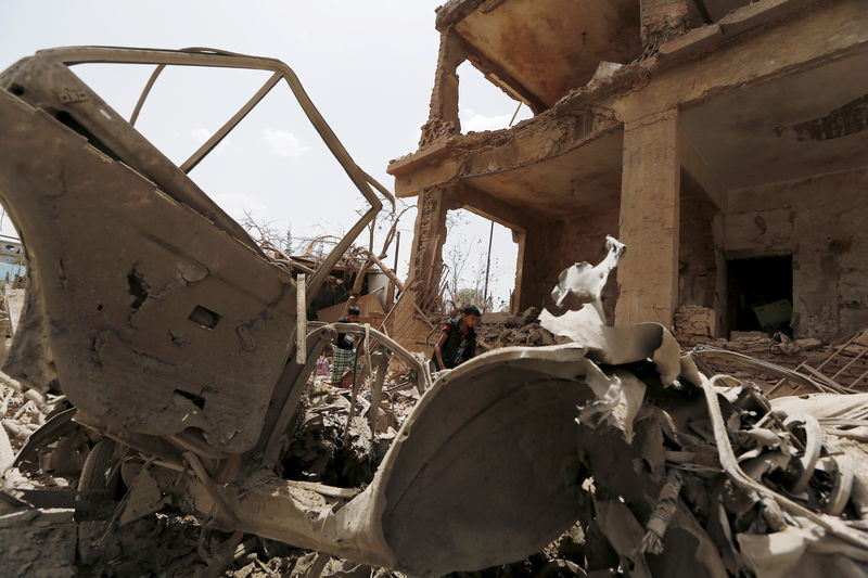 © Reuters. Boys walk at a site hit by a Saudi-led air strike in Yemen's capital Sanaa