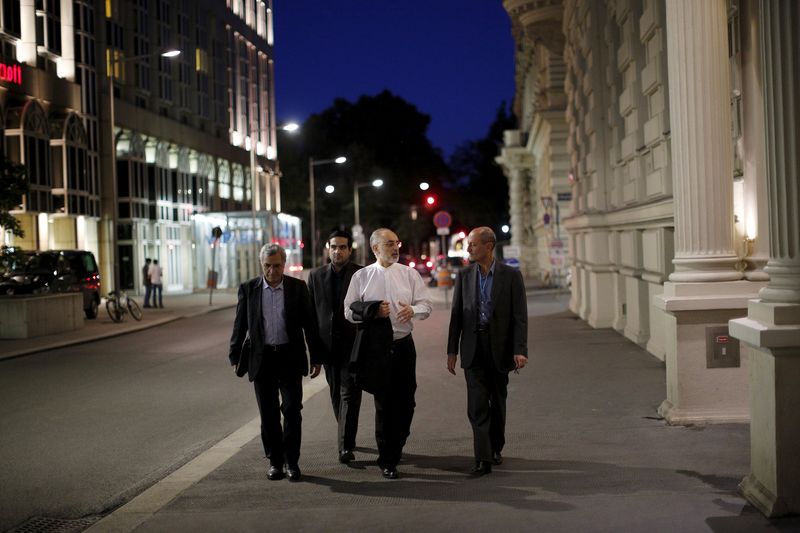 © Reuters. Head of the Iranian Atomic Energy Organization Ali Akbar Salehi (2nd R) walks near the hotel where the Iran nuclear talks meetings are being held in Vienna, Austria in Vienna, Austria