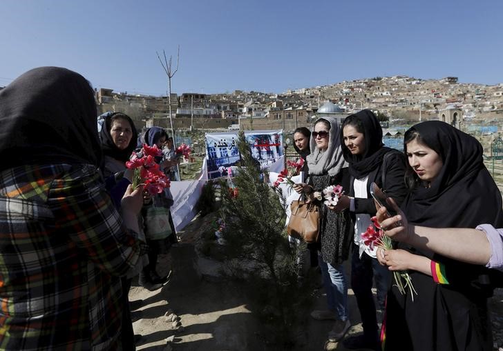 © Reuters. Afghan women's rights activists hold flowers as they gather at the grave of Farkhunda in Kabul