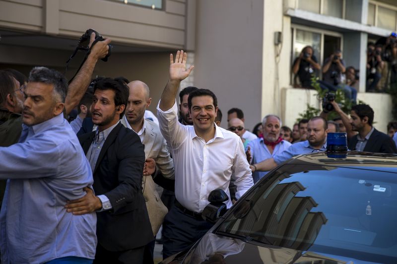 © Reuters. Tsipras waves outside at a polling station in Athens