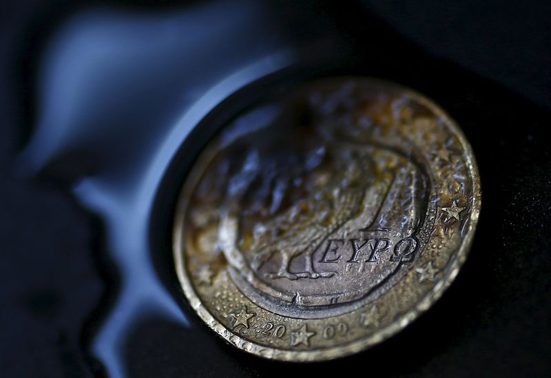 © Reuters. A one Euro coin with a Greek owl is seen burning in this picture illustration taken in Hanau