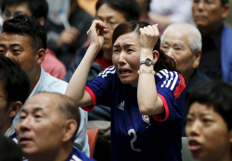 © Reuters. A Japan soccer fan reacts as she watches Japan's FIFA Women's World Cup final match against the U.S. in Vancouver, at a public viewing event in Tokyo