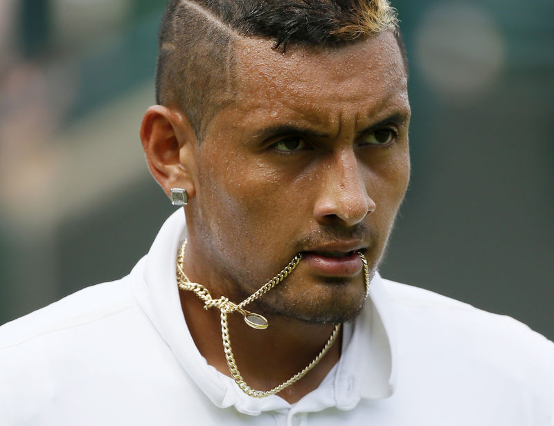 © Reuters. Nick Kyrgios of Australia holds his necklace in his mouth during his match against Juan Monaco of Argentina at the Wimbledon Tennis Championships in London