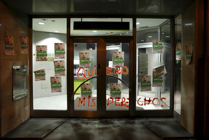 © Reuters. A graffiti that reads "I want my rights" is seen on the doors of a Bankia bank office in Madrid