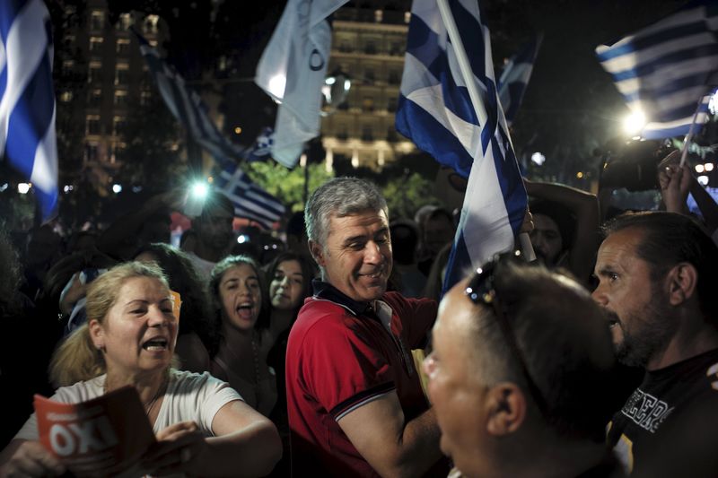 © Reuters. Pessoas comemorando o resultado do referendo, em Atenas