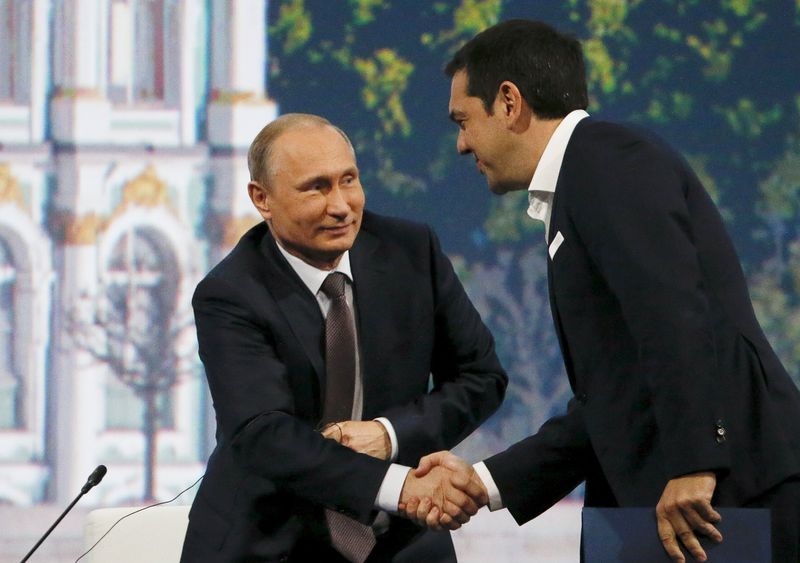 © Reuters. Russian President Putin shakes hands with Greek Prime Minister Tsipras during a session of SPIEF 2015 in St. Petersburg