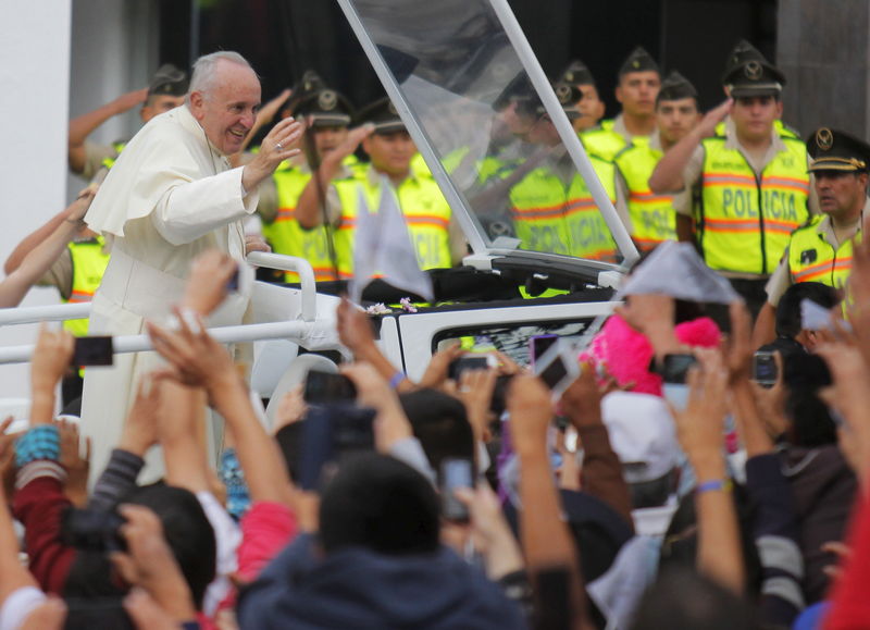 © Reuters. Pope Francis greets a crowd from the Popemobile in Quito, Ecuador