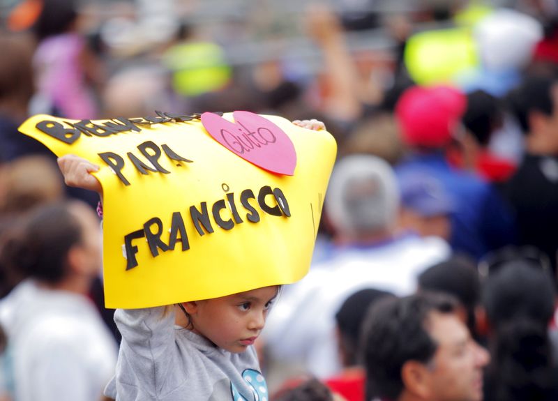 © Reuters. Menina segura cartaz escrito "Bem-Vindo, papa Francisco", enquanto espera o pontífice