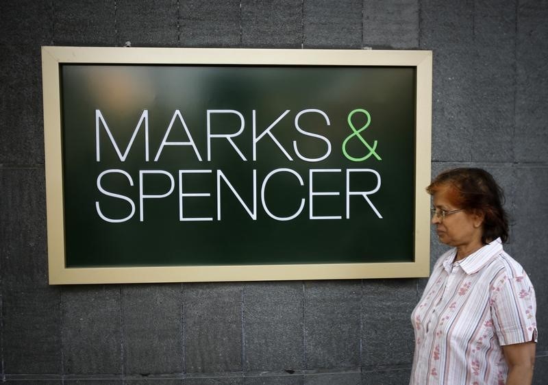 © Reuters. A woman walks past a Marks & Spencer sign outside its store in Mumbai