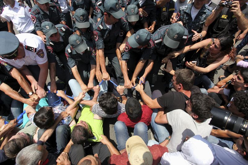 © Reuters. Protesters against a hike in electricity prices scuffle with policemen in Yerevan, Armenia