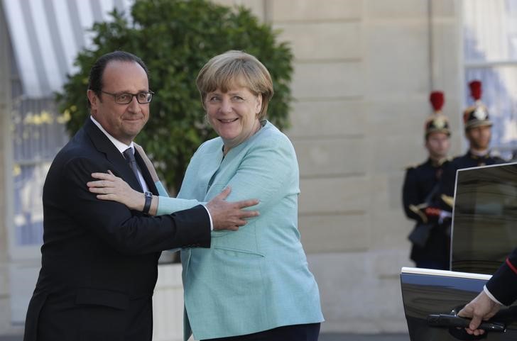 © Reuters. Il presidente francese Francois Hollande accoglie la cancelliera tedesca Angela Merkel