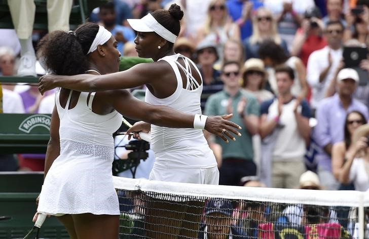 © Reuters. Serena Williams of the U.S.A. embraces Venus Williams of the U.S.A. after winning their match at the Wimbledon Tennis Championships in London