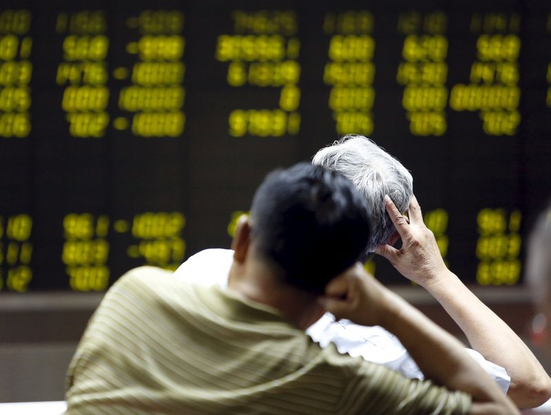 © Reuters. Investors watch an electronic board showing stock information at a brokerage office in Beijing