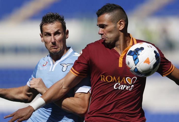 © Reuters. Leandro Castán, da Roma, disputa jogada com Miroslav Klose, da Lazio